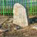 A Valenzano, un piccolo monolite cristianizzato davanti a una cancellata verde